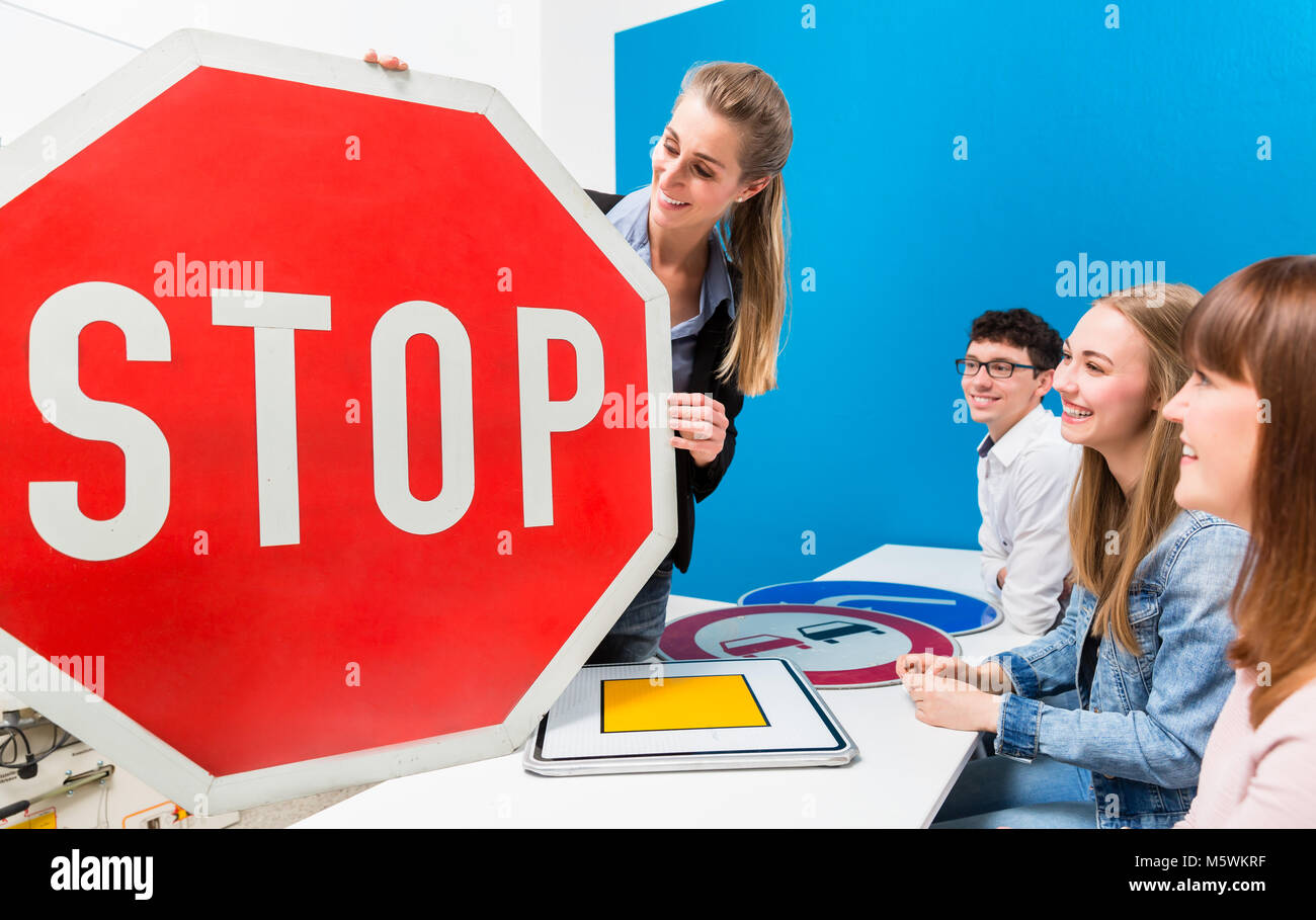 Professeur de conduite expliquant sens de plaques de rue à la classe Banque D'Images