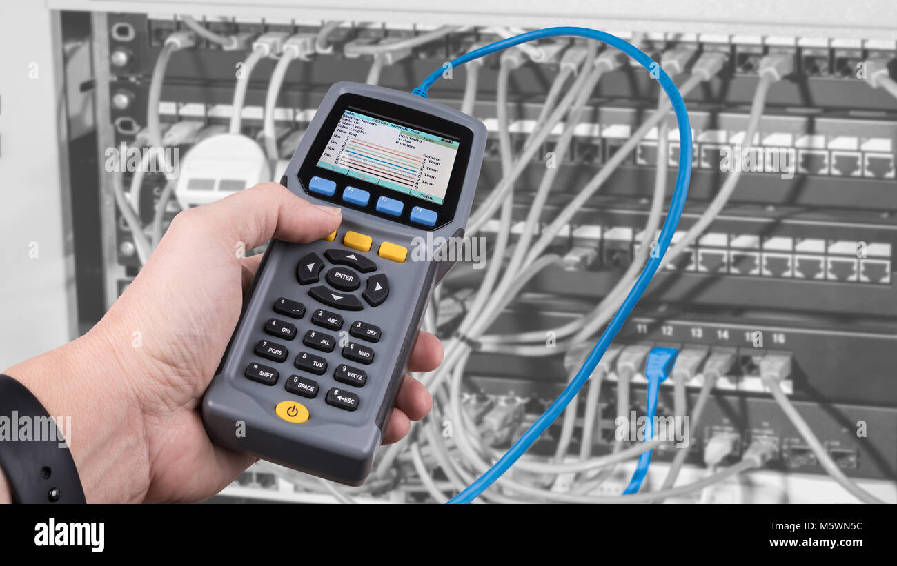 Une mesure câbles connectés dans les panneaux de rack case. Détail de l'homme part lors du test de câble câblage structuré par des tests de performances. Banque D'Images