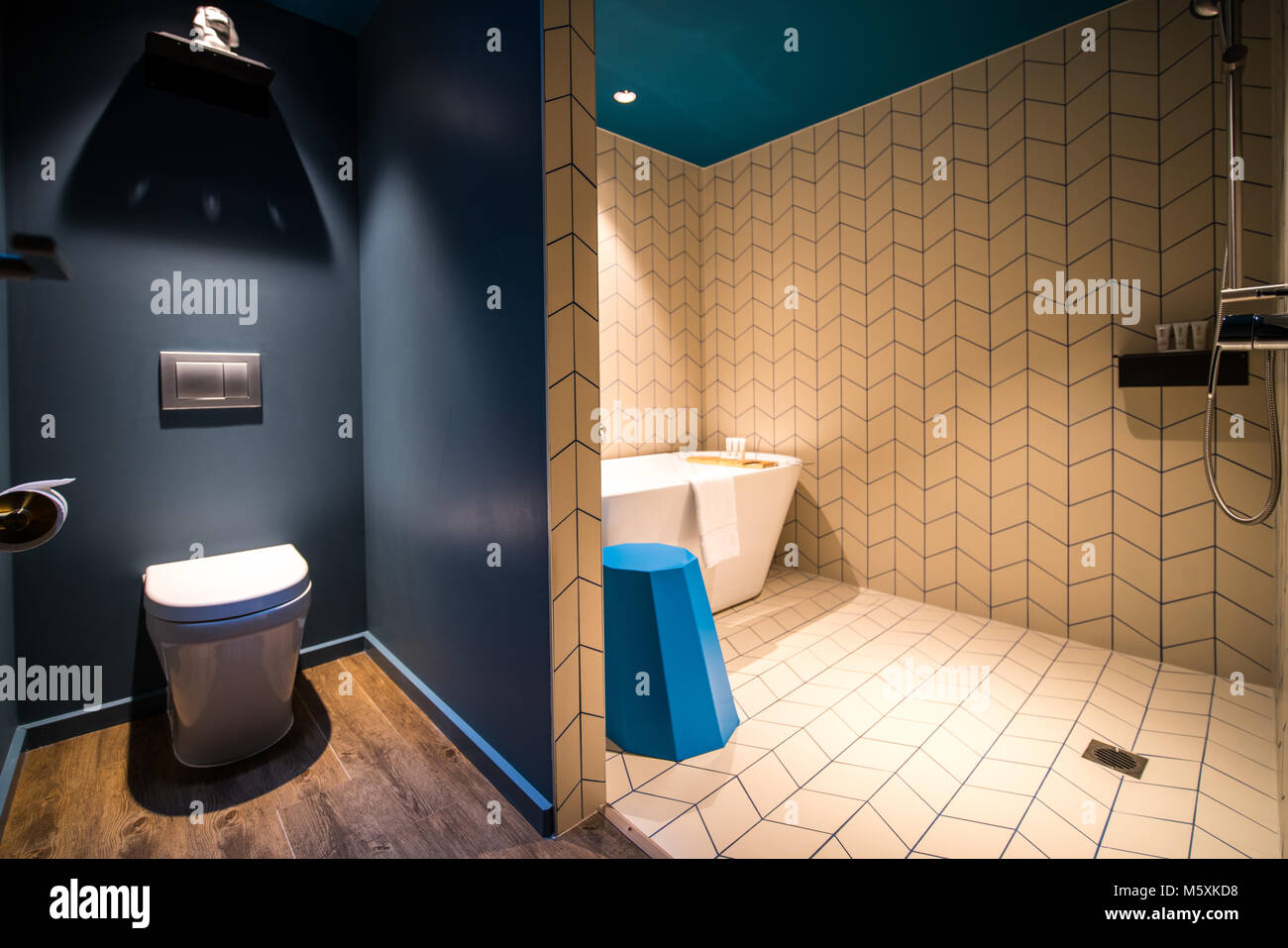 Salle de bains moderne de luxe avec baignoire, serviettes blanc et bleu tabouret Banque D'Images