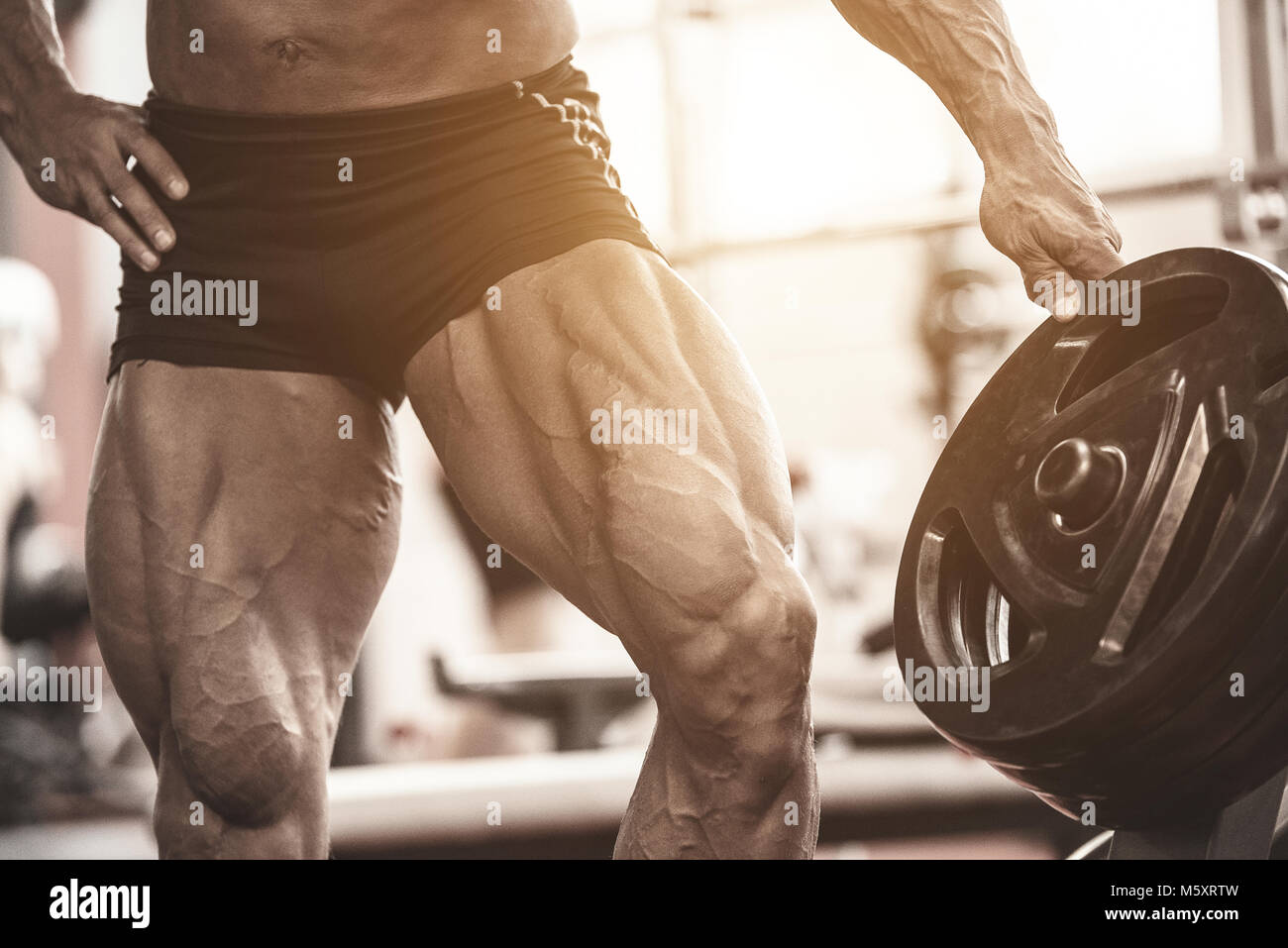 Close-up de bodybuilders jambes musclées. L'homme faisant l'exercice d'entraînement de l'athlète en sport Banque D'Images