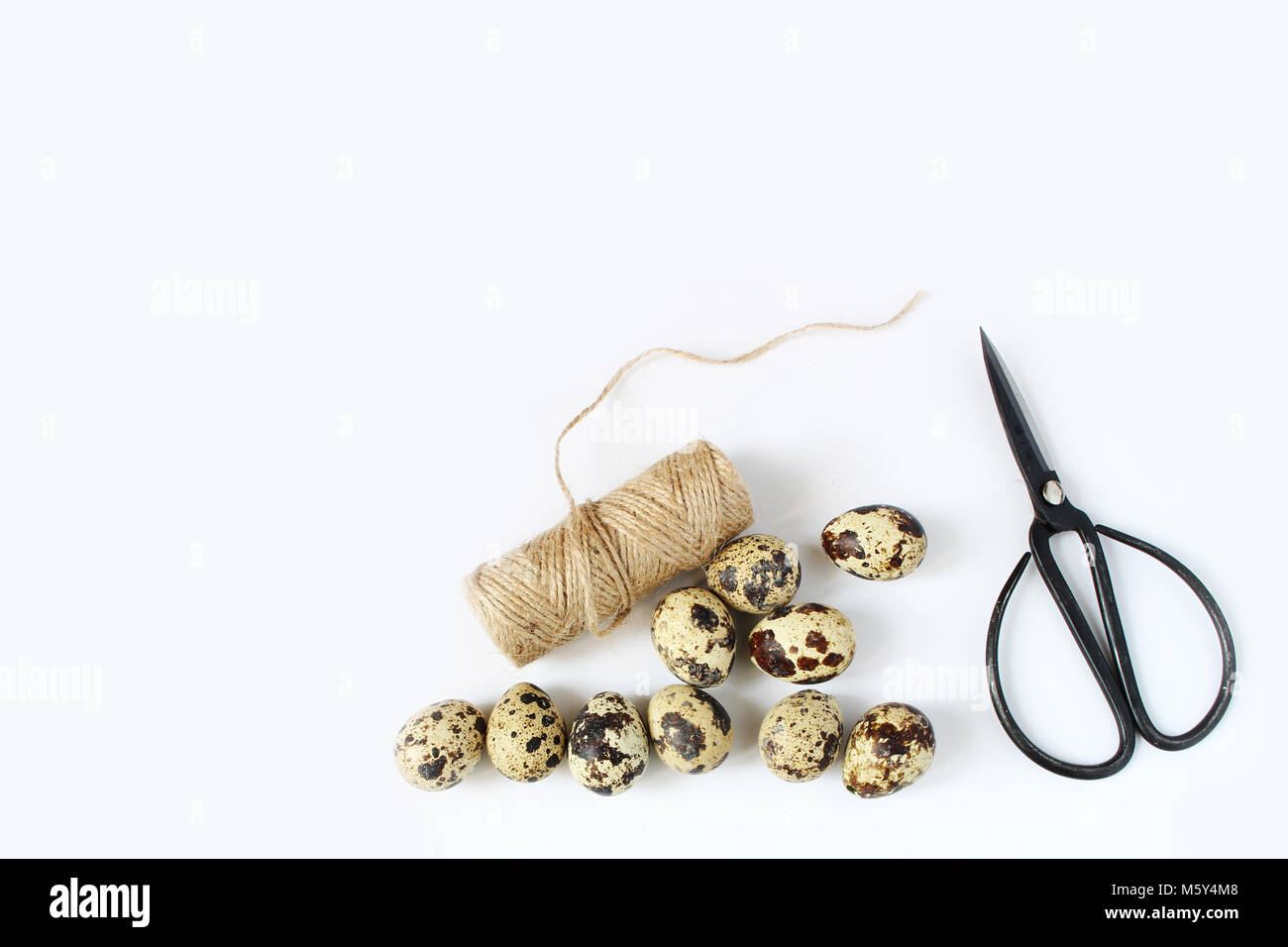 Printemps Pâques, carte de vœux, invitation avec des oeufs de cailles, ciseaux noir et blanc naturel corde sur table. Style Féminin télévision stock lay photo, vue d'en haut. Banque D'Images
