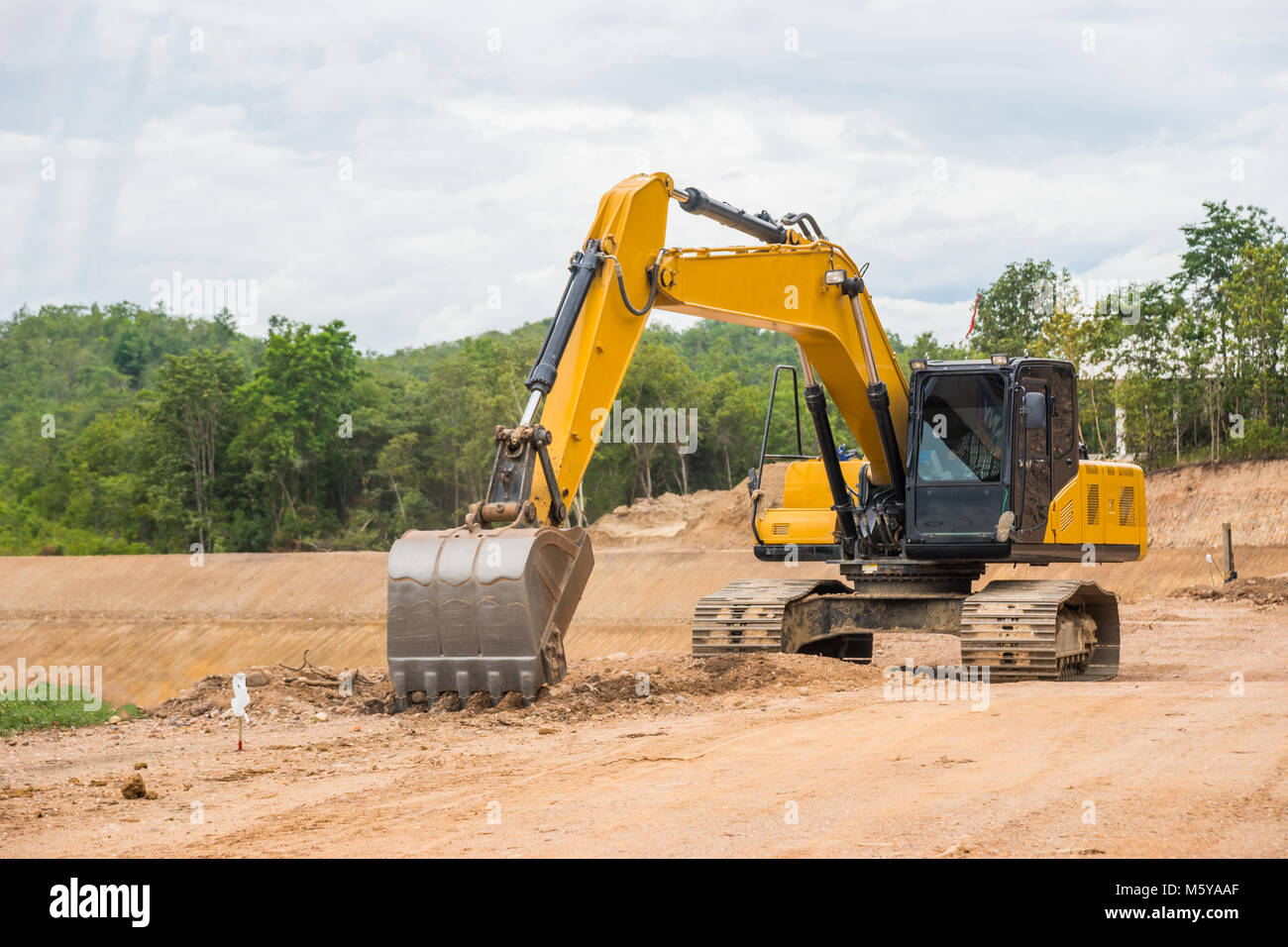 Pelleteuse jaune d'excaver le sol et du sable pour la construction d'eau du réservoir. Banque D'Images