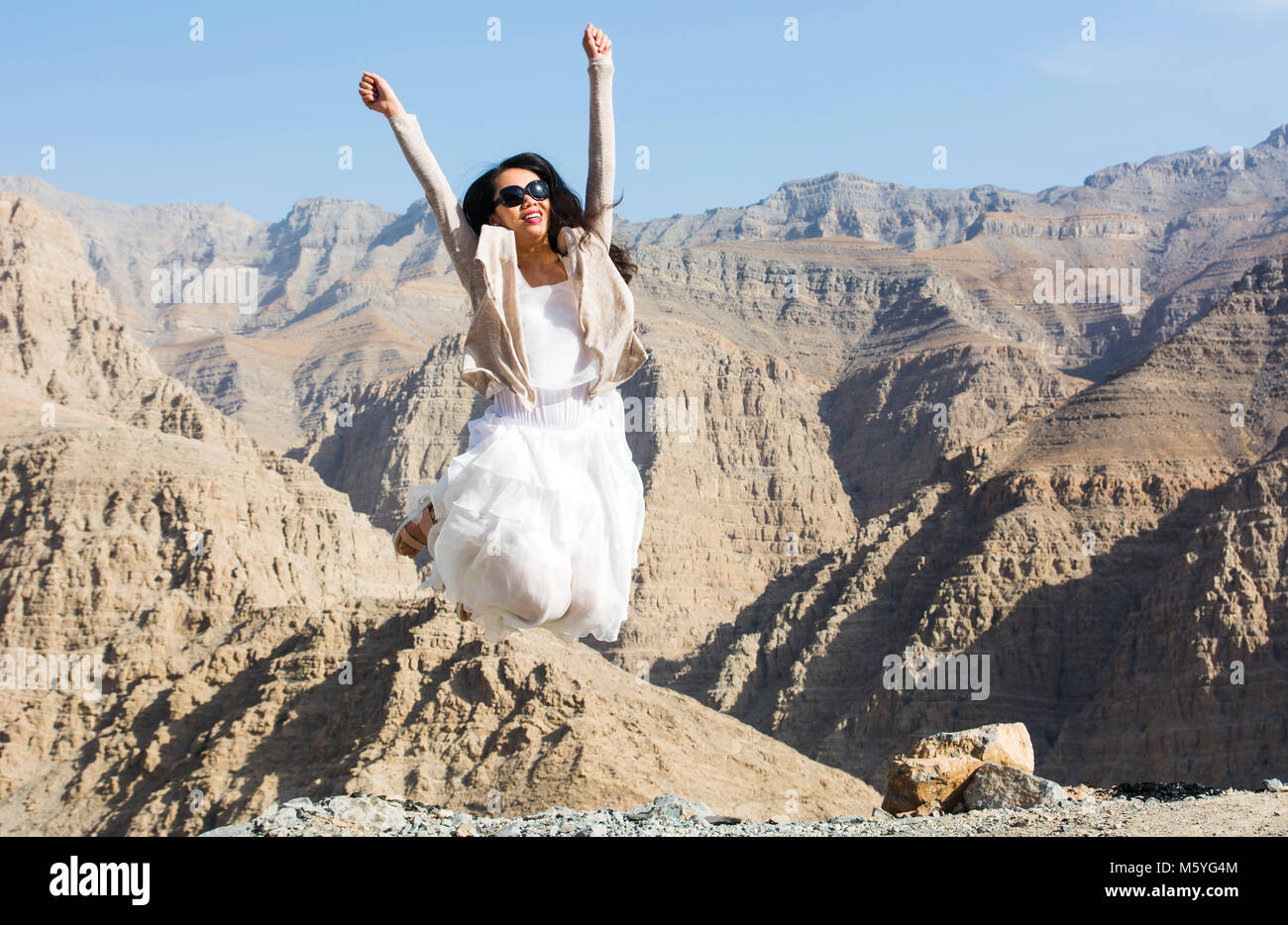 Happy girl jumping on the mountain top avec vue Banque D'Images