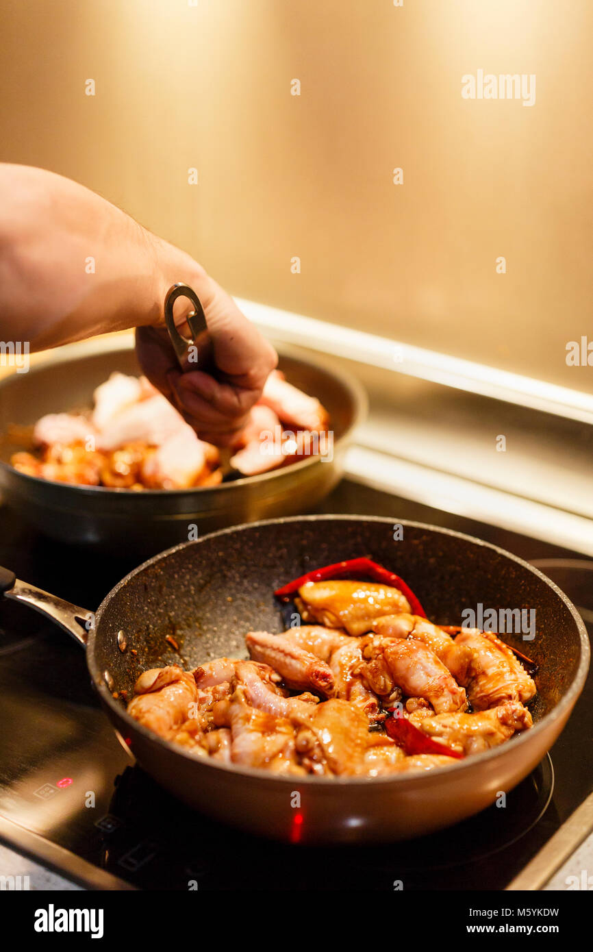 L'homme qui cuisine ailes de poulet au wok d'Asie Photo Stock - Alamy