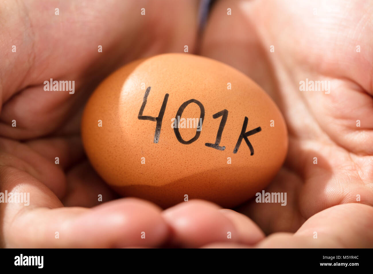 Close-up d'une main humaine avec Brown Egg montrant Texte Pension Banque D'Images