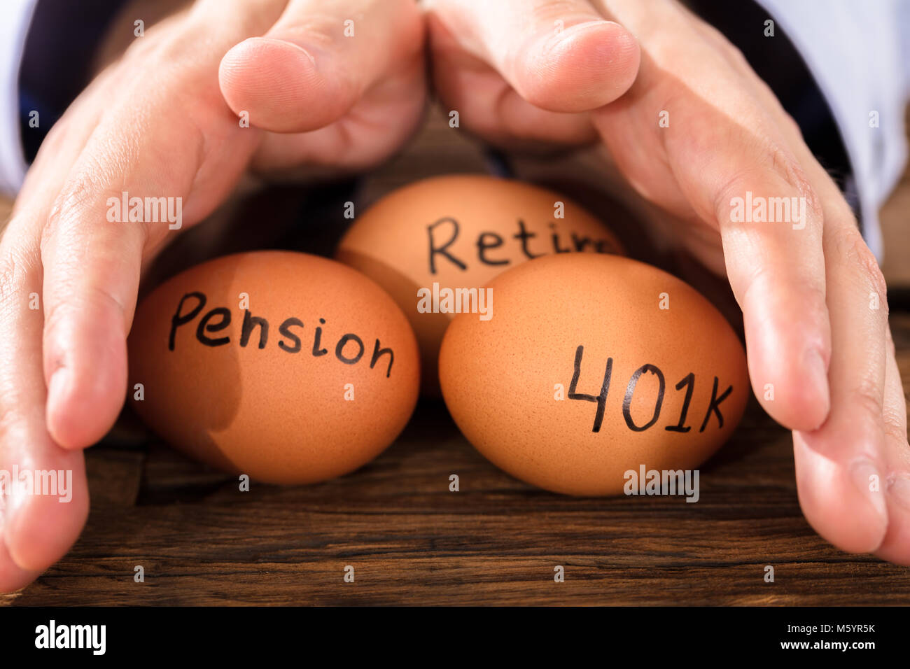 Close-up of a person's hand protection Brown Egg montrant Pension et retraite Text Banque D'Images