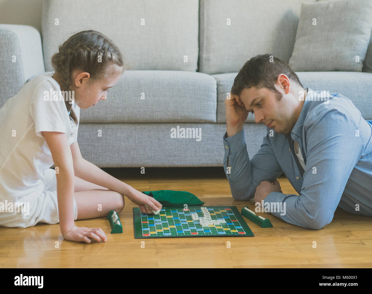 Petite fille et son père jouant au Scrabble jeu de plateau. Banque D'Images