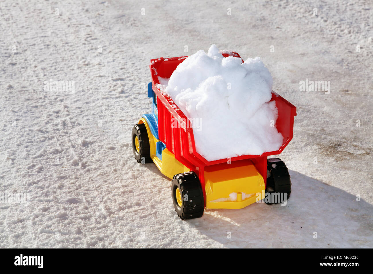 Camion jouet enlève la neige sur la route en hiver Banque D'Images