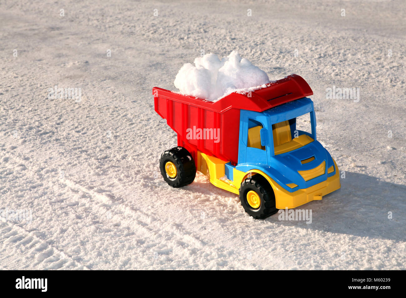 Camion jouet enlève la neige sur la route en hiver Banque D'Images
