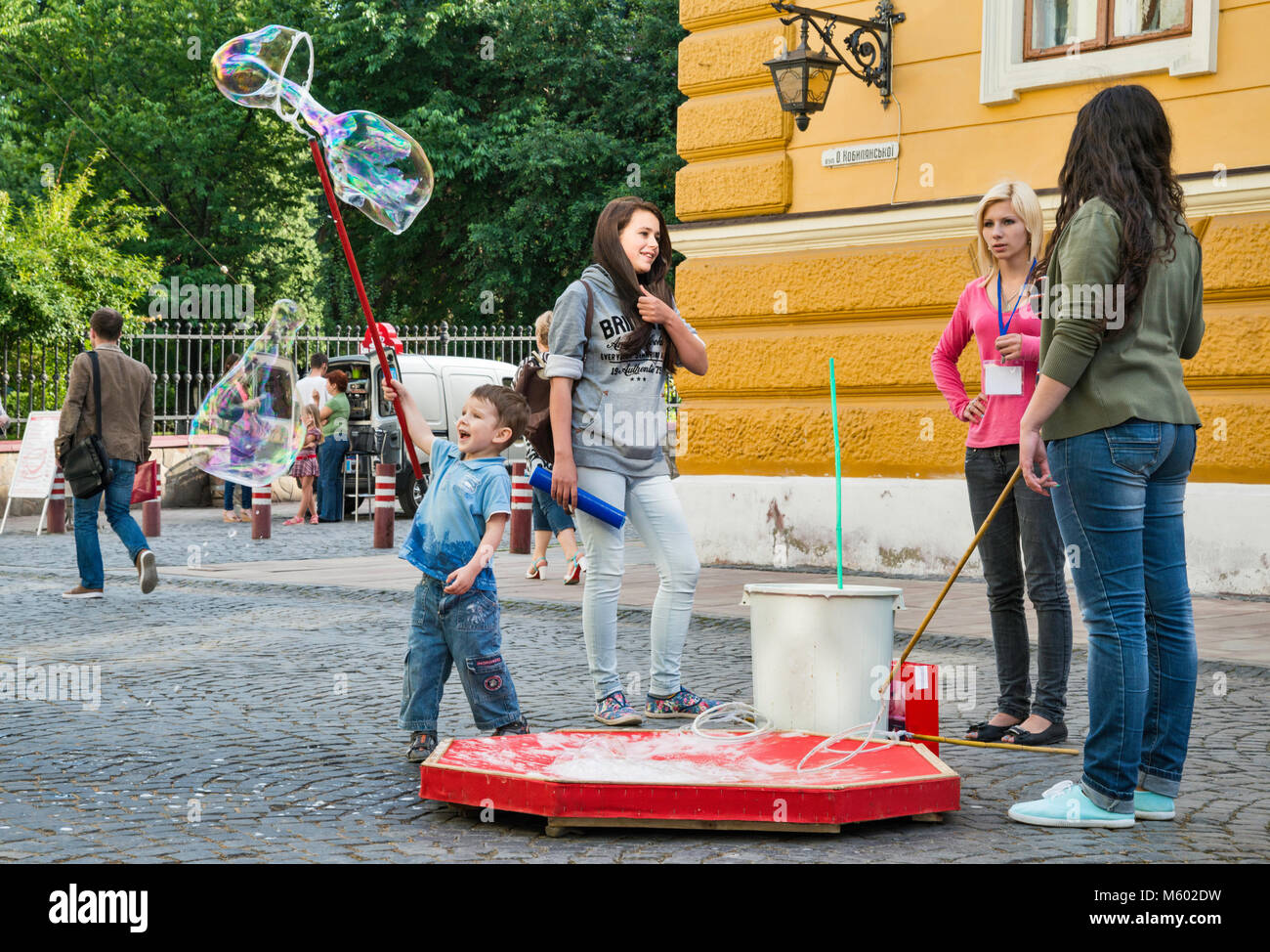 Jeune garçon faisant des bulles à Olha Kobylianska Street zone piétonne à Tchernivtsi, Ukraine, région de Bucovine Banque D'Images