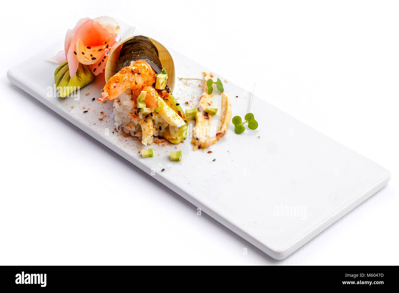 Rouleaux de Sushi sur une plaque blanche avec fond blanc. Banque D'Images