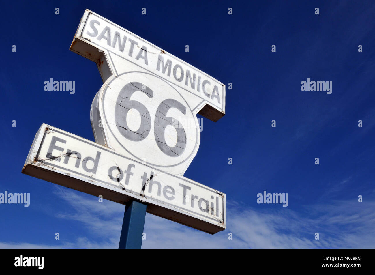 Le signe marquant la limite ouest de la route 66 se trouve sur la jetée de Santa Monica en Californie contre un brillant ciel bleu. Banque D'Images