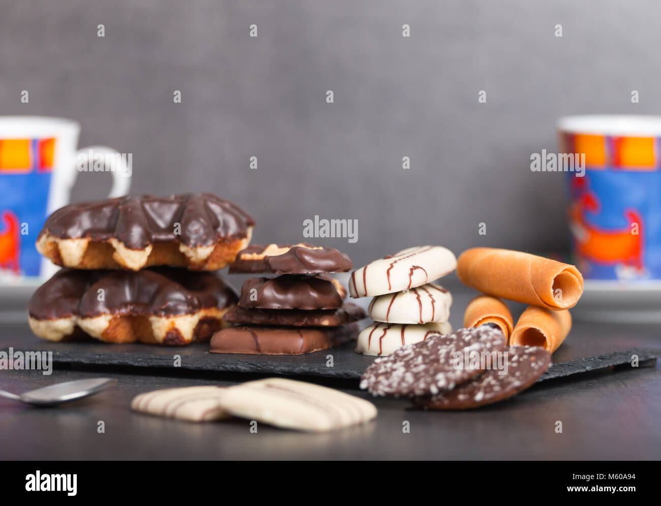 Variété de biscuits au chocolat et café sur une table avec des bougies et des fleurs Banque D'Images