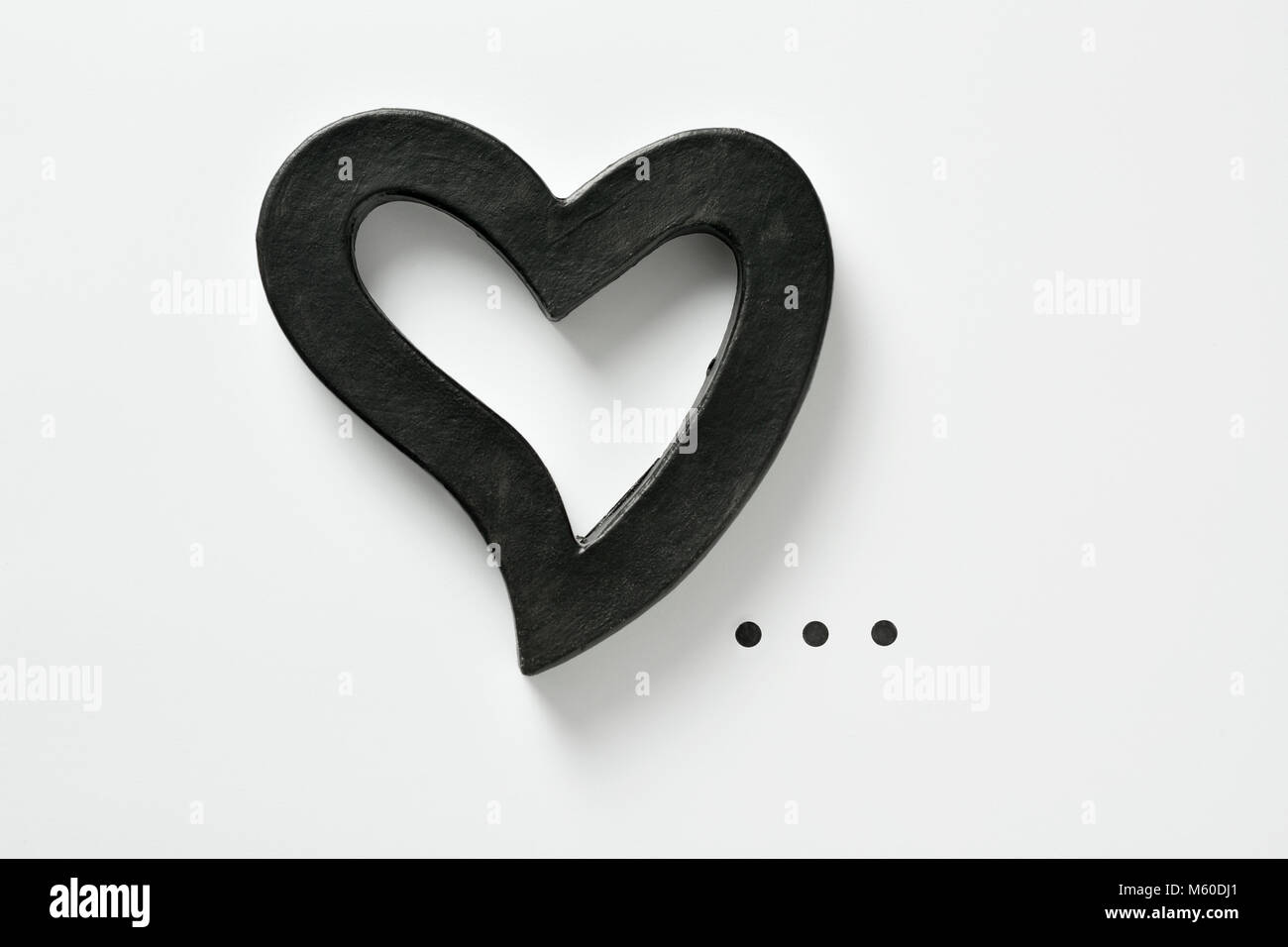 Libre d'un noir coeur en trois dimensions et points de suspension sur un fond blanc, avec un peu d'espace vide autour d'eux Banque D'Images