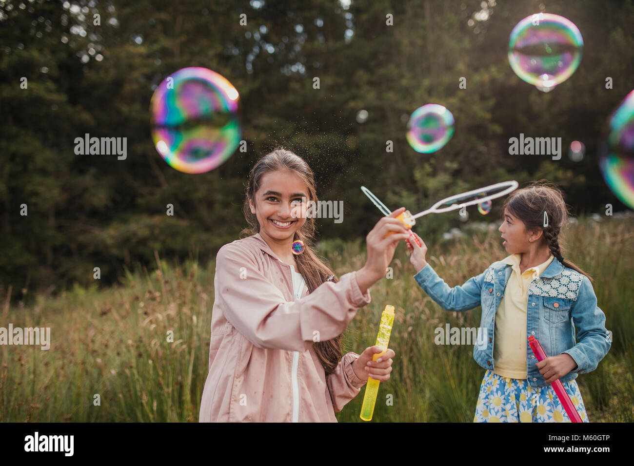 Deux petites filles, la création de bulles dans la forêt sur leurs vacances. Banque D'Images