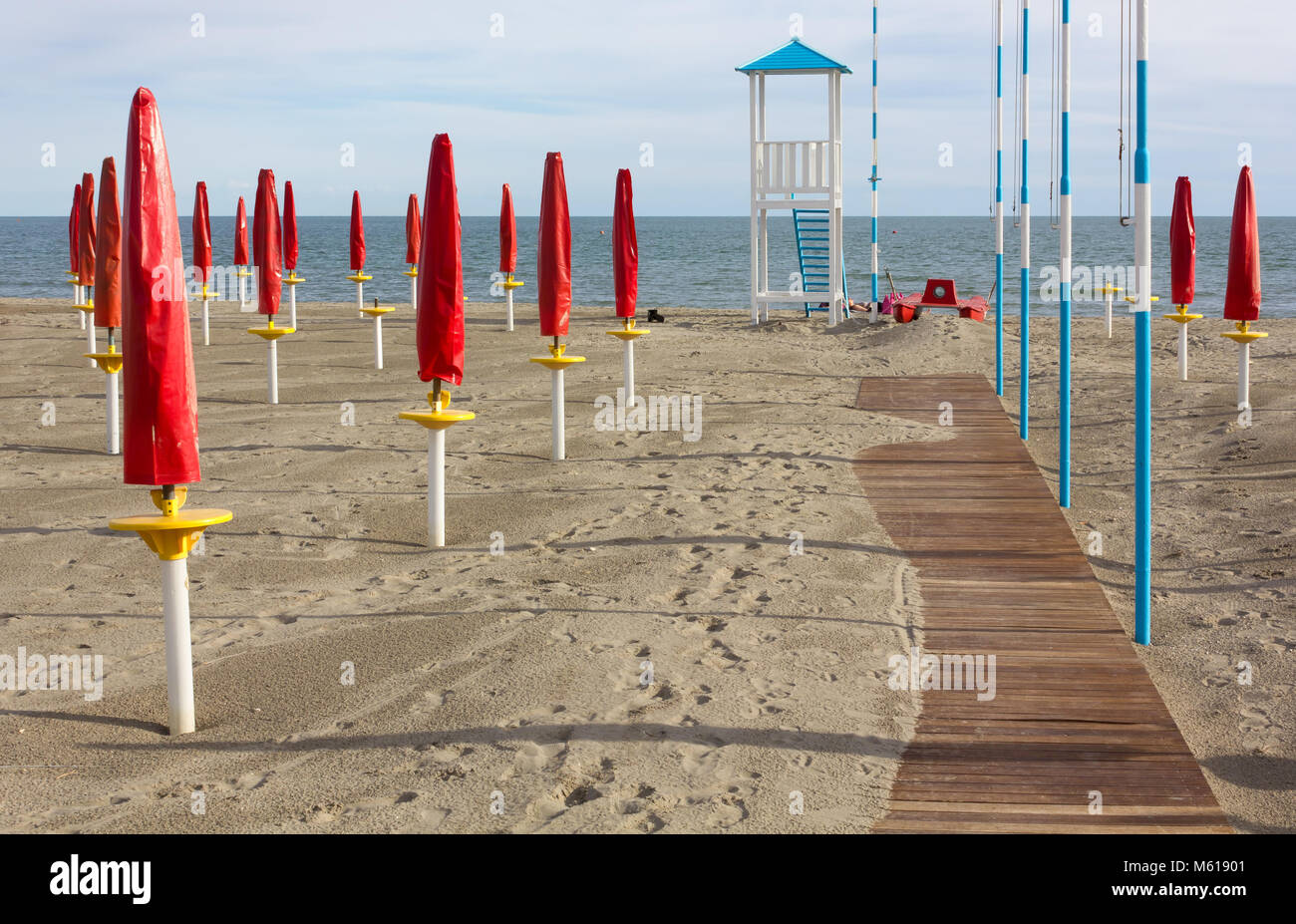 Plage de sable vide fermé avec un parapluie rouge, d'une promenade et d'un sauveteur vigie Banque D'Images