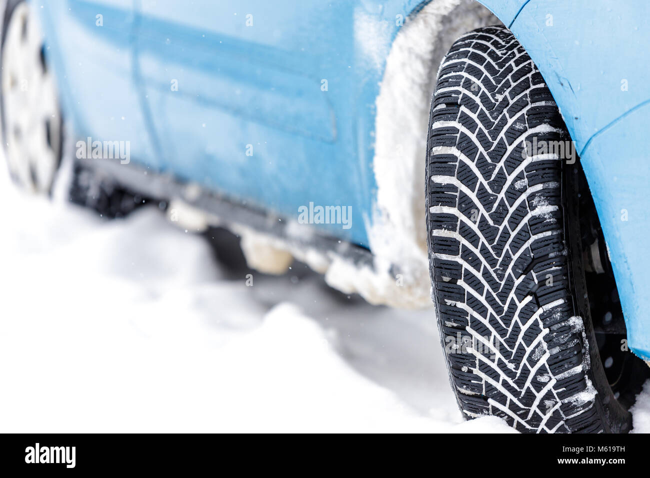 Pneu de voiture couverte de neige en hiver.sur route avec de la neige fraîche. close up. Banque D'Images