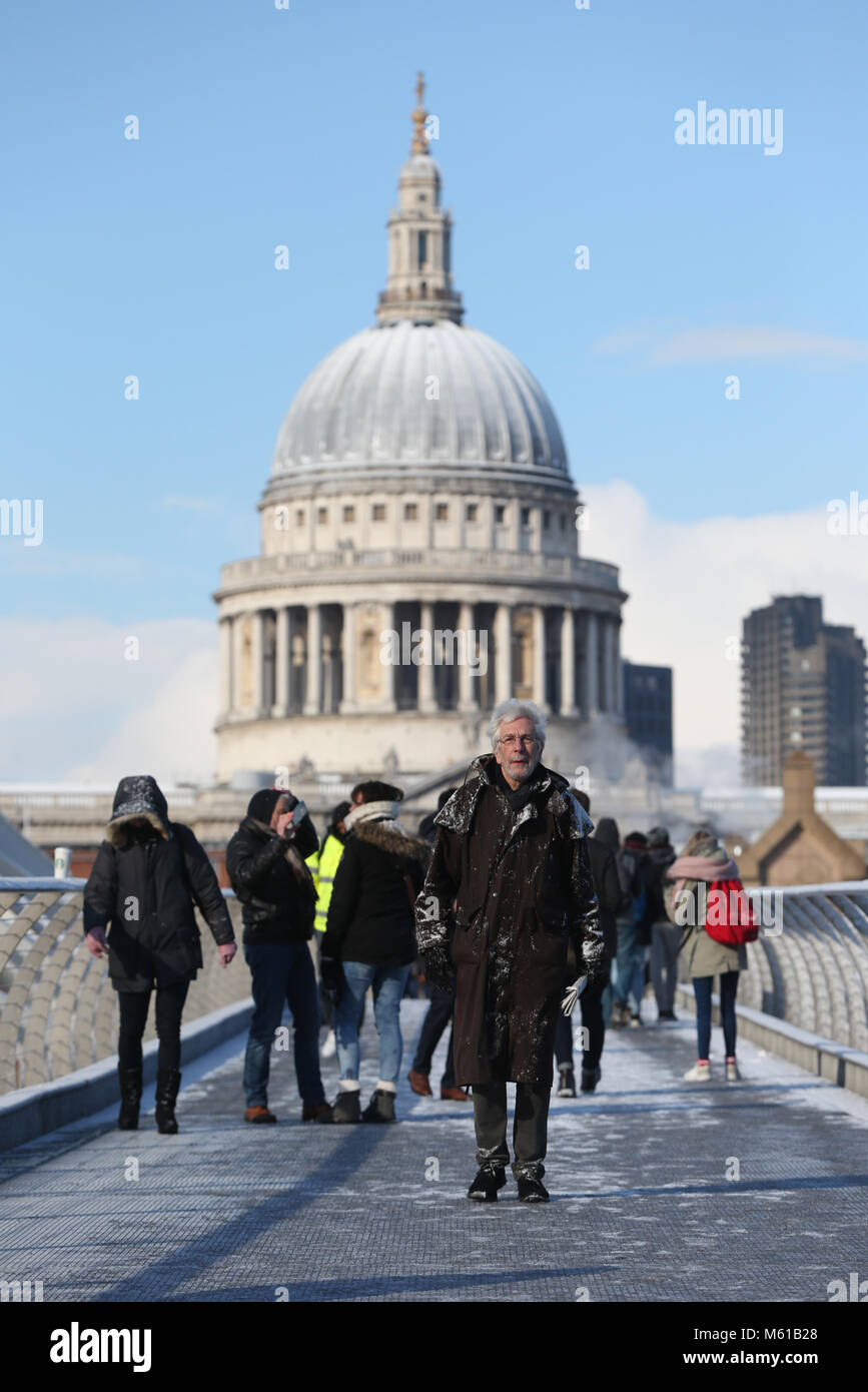 Les gens marcher sur un harfang Millennium Bridge, à Londres, que les fortes chutes de neige sur les routes de l'UK mardi matin après plusieurs centimètres a diminué dans certaines régions au cours de la nuit. Banque D'Images