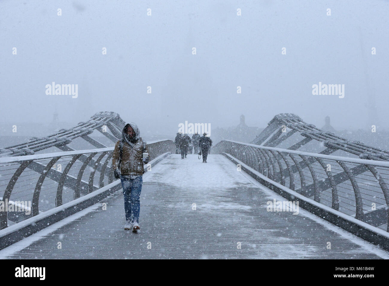 Les gens à pied sur le pont du Millénaire dans la neige, à Londres, que les fortes chutes de neige sur les routes de l'UK mardi matin après plusieurs centimètres a diminué dans certaines régions au cours de la nuit. Banque D'Images