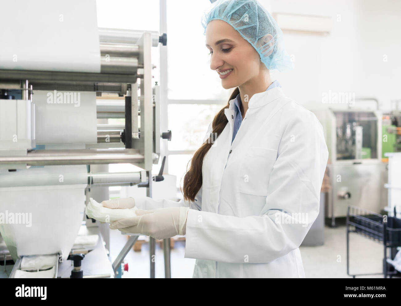 Employé heureux portant manteau de laboratoire lors de la manipulation de lingettes stériles Banque D'Images