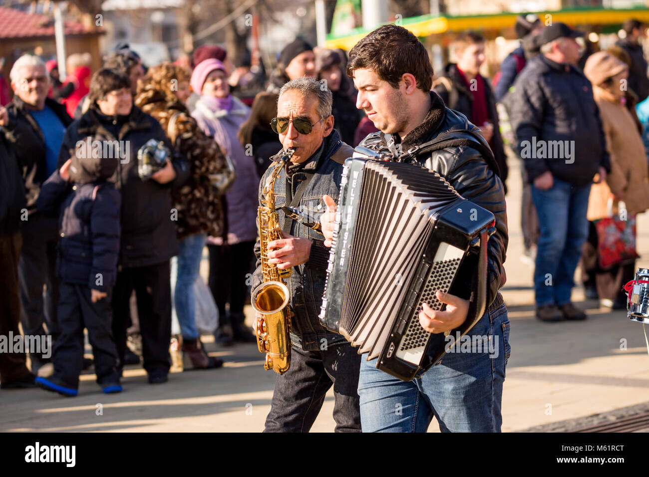 PERNIK, BULGARIE - 26 janvier 2018 : Ancien musicien de rue avec des cheveux blancs et lunettes de saxophone joue en marchant à l'édition 2004 du International Fest Banque D'Images