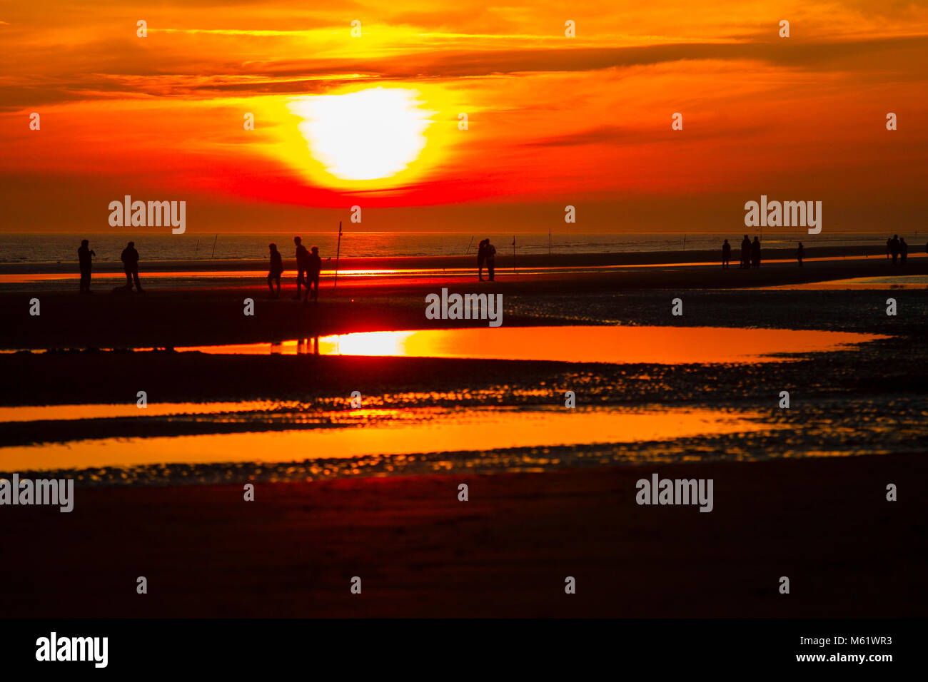 Les gens se promener sur la plage à Rindby au coucher du soleil, la veille du Solstice Banque D'Images