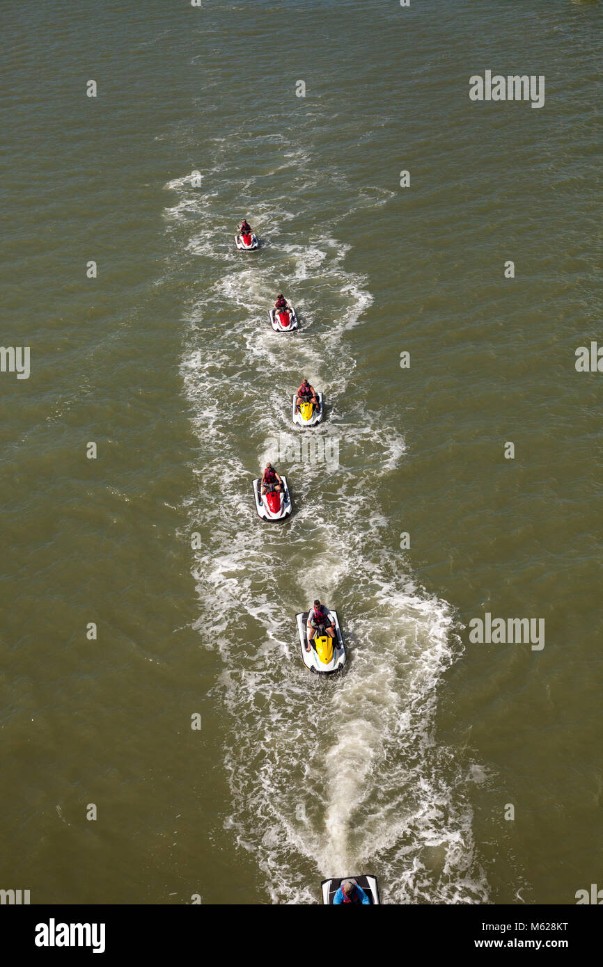 Groupe de jet ski zip le long de l'océan, en ligne droite, fait des vagues dans l'océan dans la baie en face de Marco Island, Floride Banque D'Images