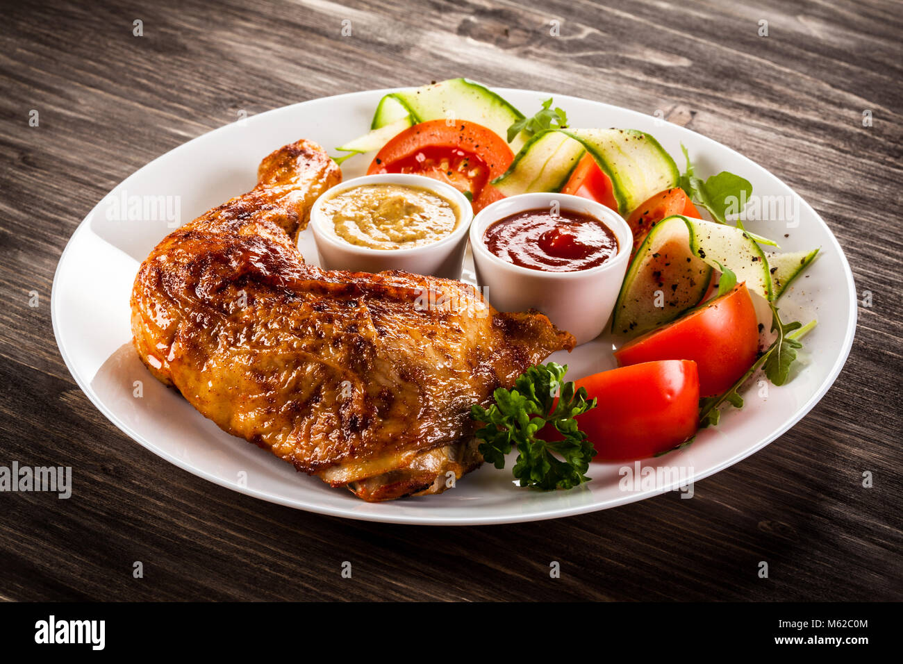 La Turquie grillé avec frites et légumes jambes sur table en bois Banque D'Images