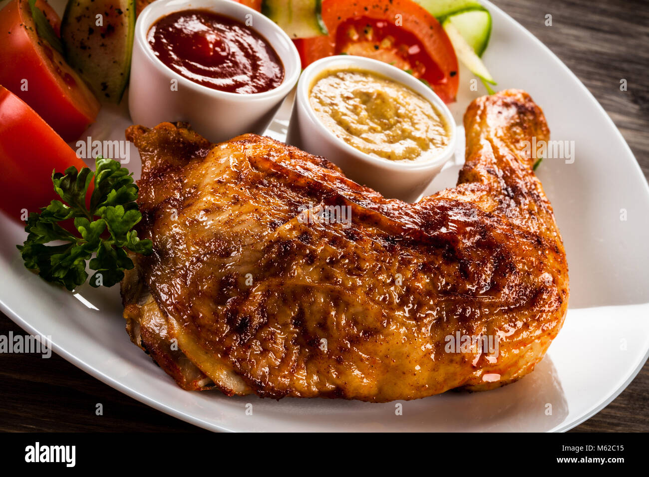 La Turquie grillé avec frites et légumes jambes sur table en bois Banque D'Images