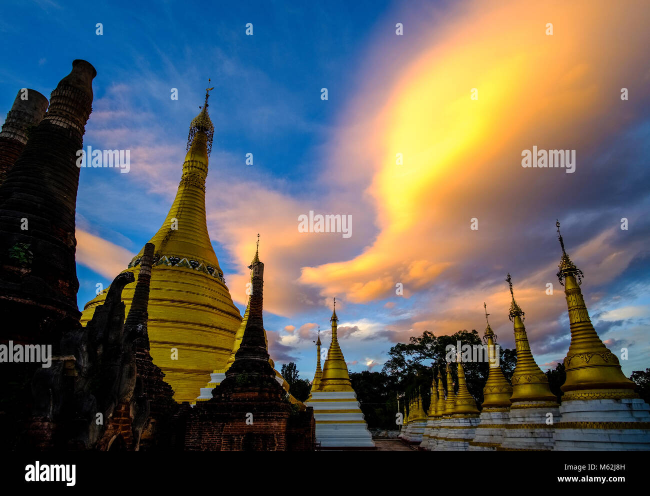 Coucher du soleil avec des nuages sur les pagodes d'or Banque D'Images