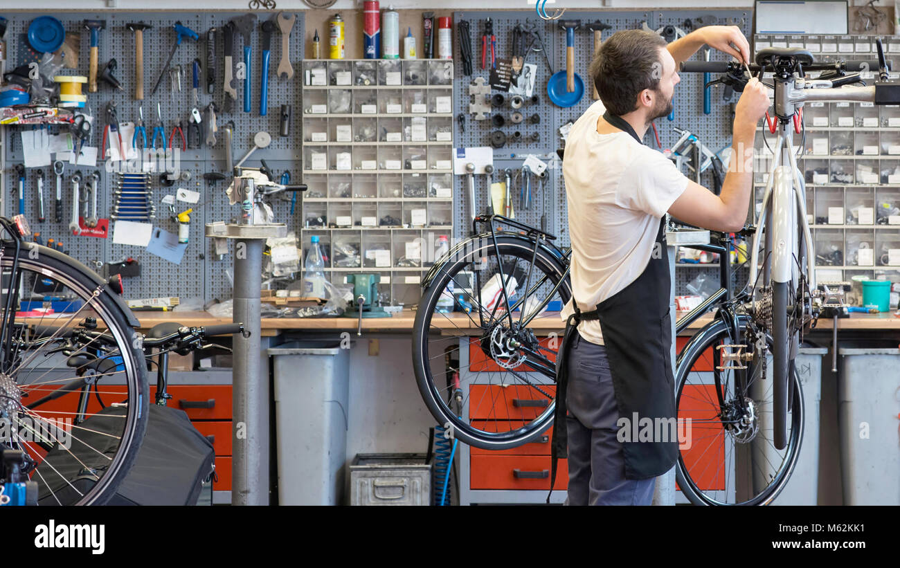 Mécanicien vélo sympa et compétent dans un atelier de réparation de vélo Banque D'Images