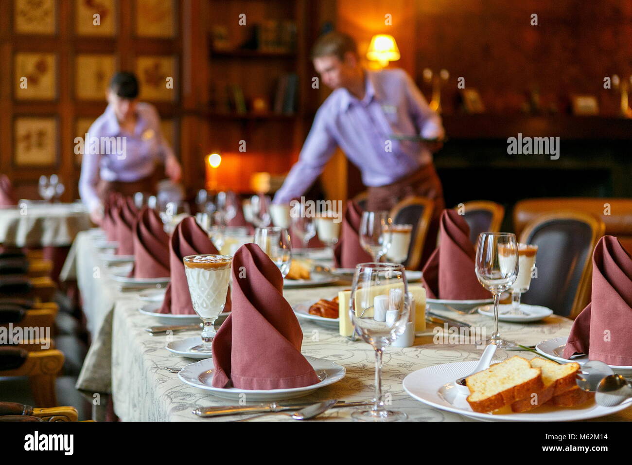 Serveurs préparer une table pour le petit déjeuner. L'arrière-plan. L'avant-plan de serviettes, vaisselle, toasts, verres. Atmosphère calme Banque D'Images