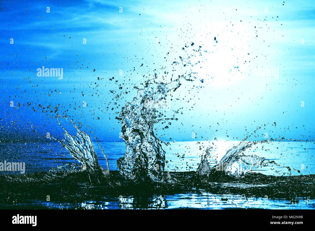 Fresh cool water splash au coucher du soleil par une mer bleue. Résumé fond bleu. Concept motion gel Banque D'Images