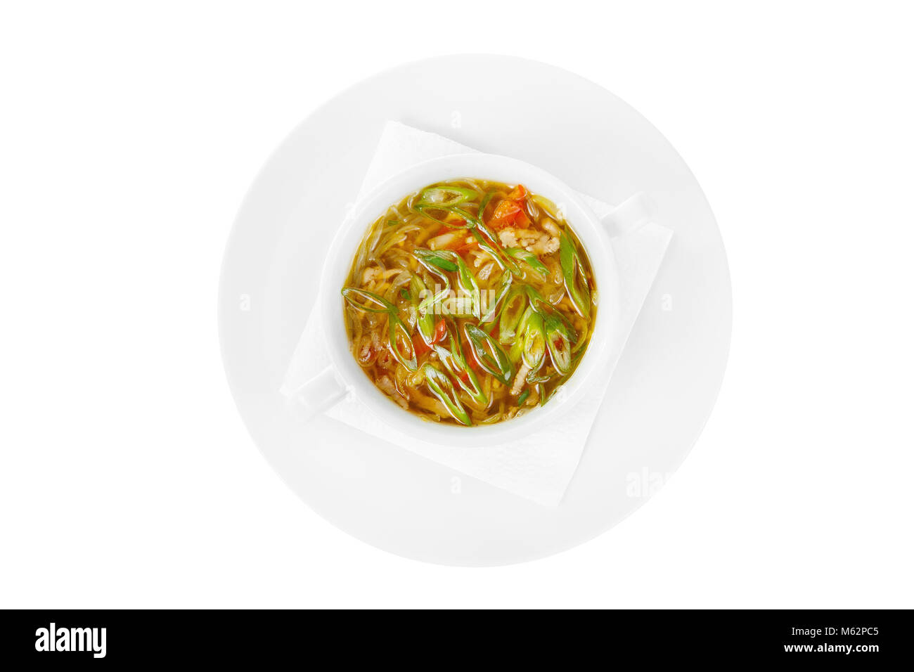 Soupe aux légumes, Transparent, nouilles, fuchozoj, verts, oignons, poivre, poulet. Sur une serviette dans une assiette blanche blanc isolé. Plats de service en Banque D'Images