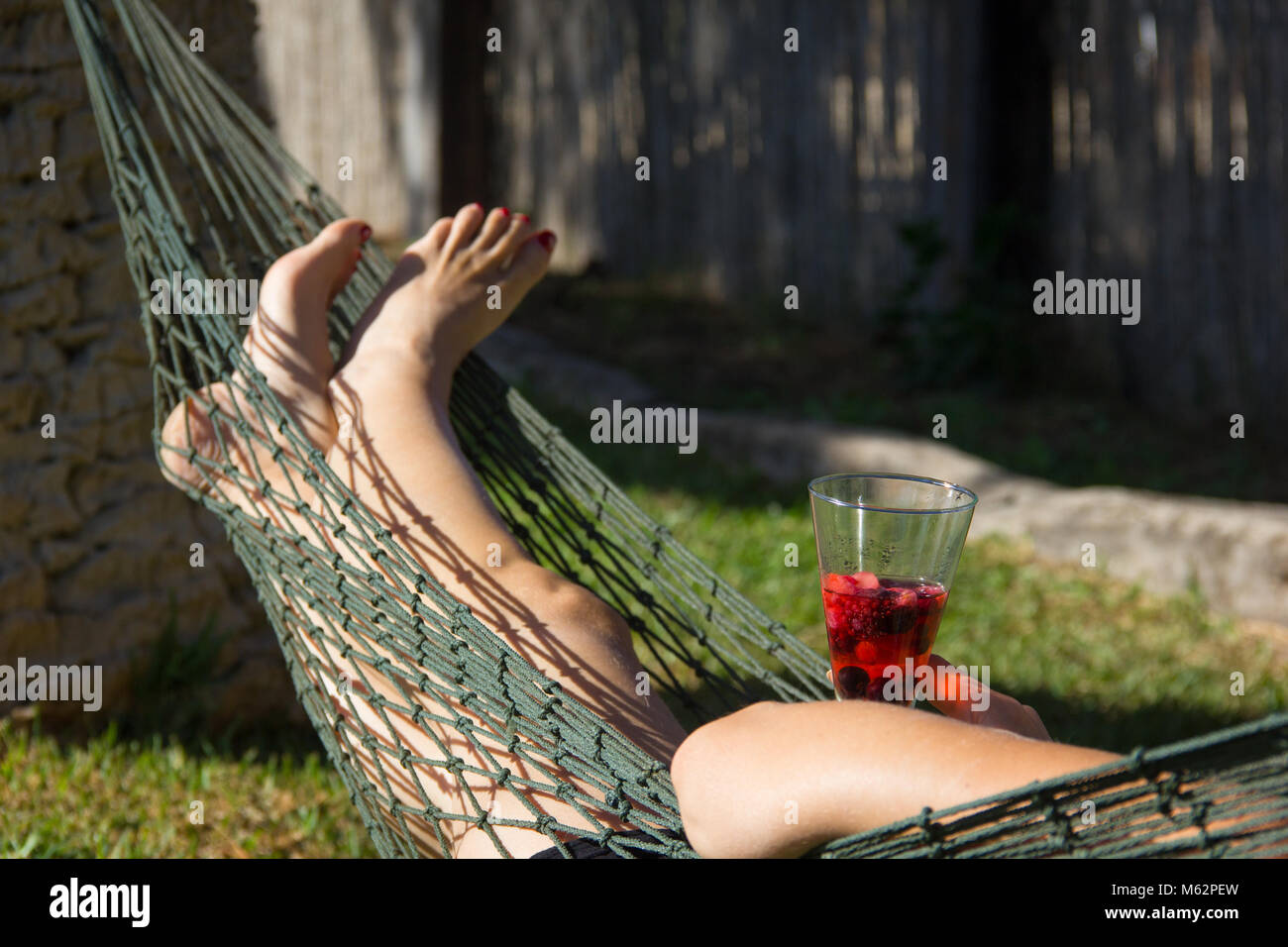 Femme sur jardin hamac filet chilling out holding cocktail glass avec  pommes et poires. Se détendre, se reposer concept Photo Stock - Alamy