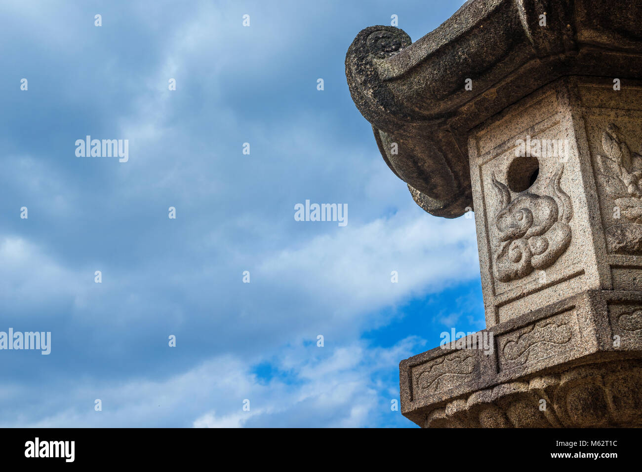 La lanterne de pierre japonais traditionnel ancien, un type se trouvent souvent dans des jardins (avec des nuages et de l'espace de copie) Banque D'Images
