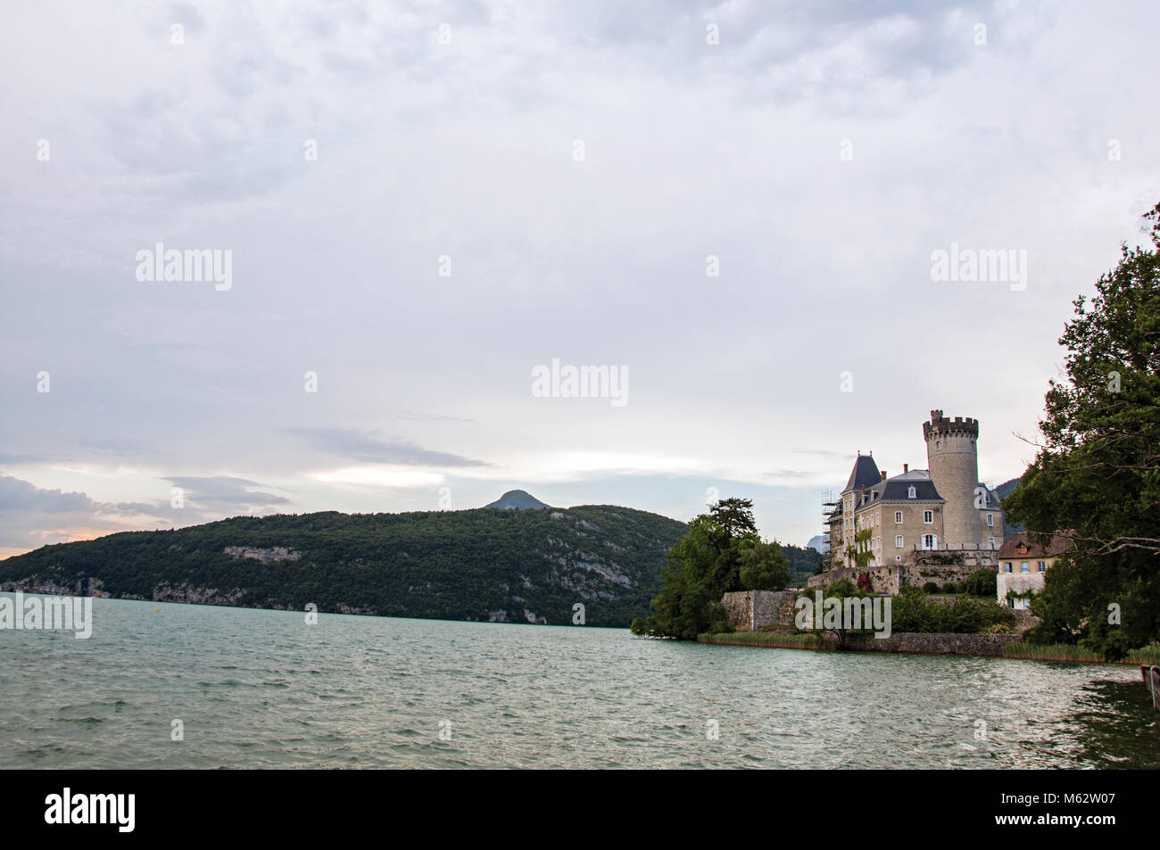 Duingt château avec des paysages de montagne et ciel nuageux à côté lac d'Annecy, près d'Annecy. Département de Haute-Savoie, dans le sud-est de la France. Banque D'Images