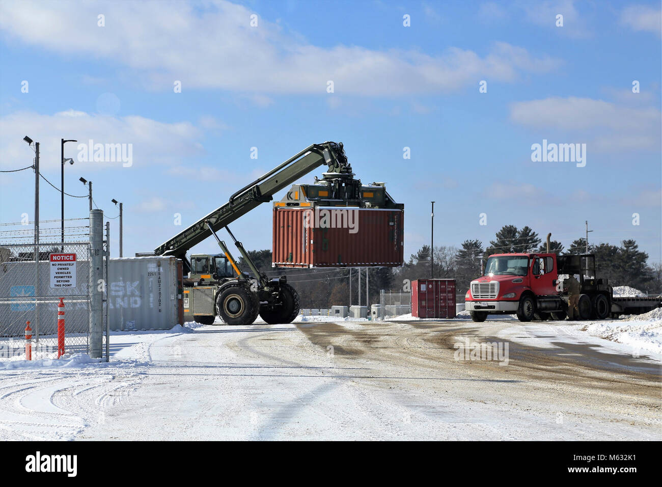 Un opérateur d'équipement lourd avec le Centre de préparation logistique des transports utilise un gestionnaire de chariots élévateurs tous terrains pour conteneurs/Loader pour charger un conteneur sur une remorque près du bâtiment 2100 Le 7 février 2018, à Fort McCoy. Le container/chargeur est capable de soulever certains des plus grands contenants d'expédition et de chargement des conteneurs sur wagons ou remorques soit. (U.S. Army Banque D'Images