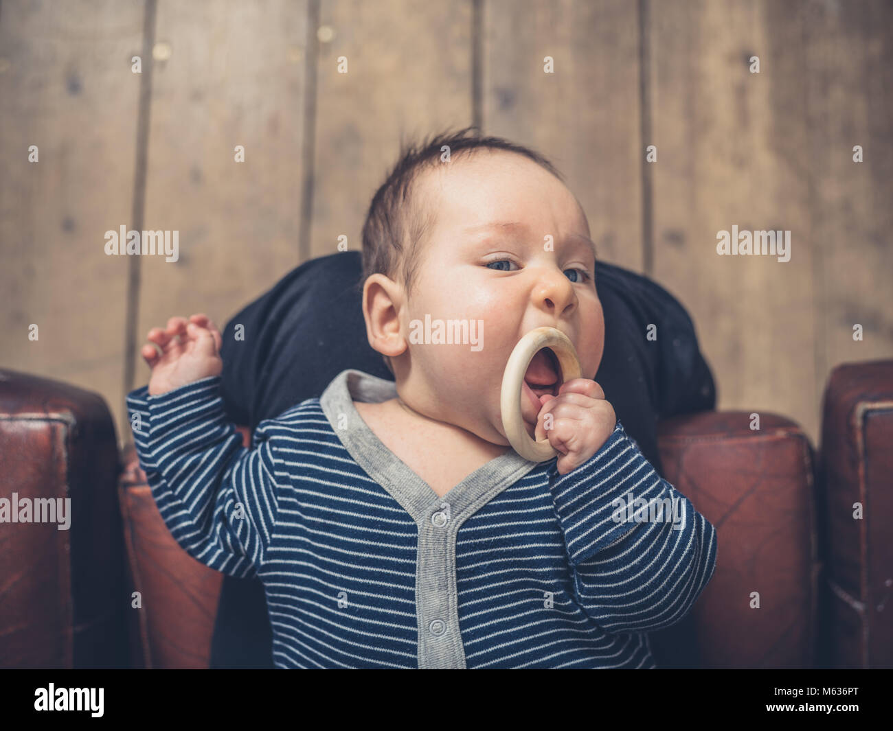 Un petit bébé est à mâcher sur un anneau de dentition Banque D'Images