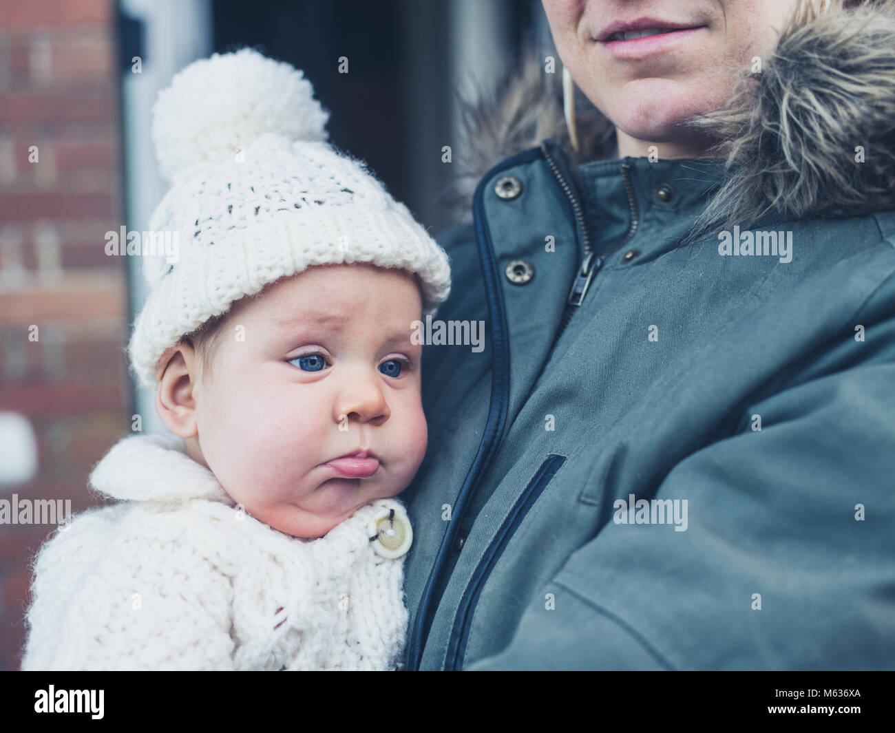 Une jeune mère et bébé dans des vêtements d'hiver à l'extérieur de la chambre Banque D'Images