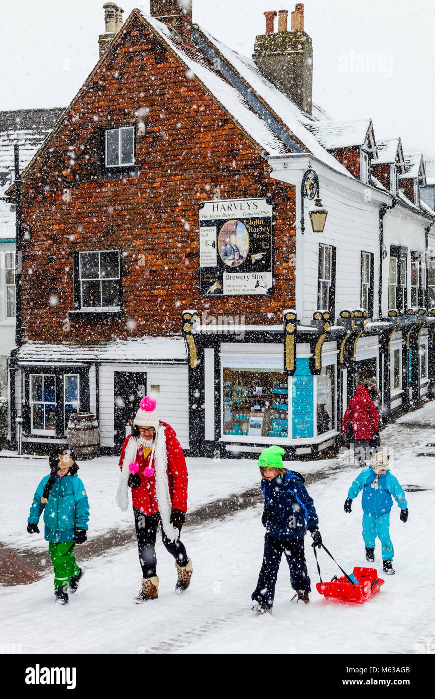 Avec les écoles fermées en raison de la mauvais temps une famille prenez le temps d'aller faire de la luge, High Street, Lewes, dans le Sussex, UK Banque D'Images