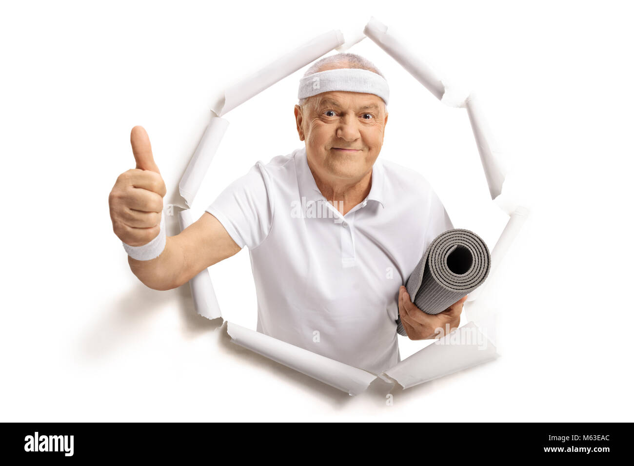 Personnes âgées sportsman avec un tapis d'exercice briser de papier et en un thumb up sign Banque D'Images