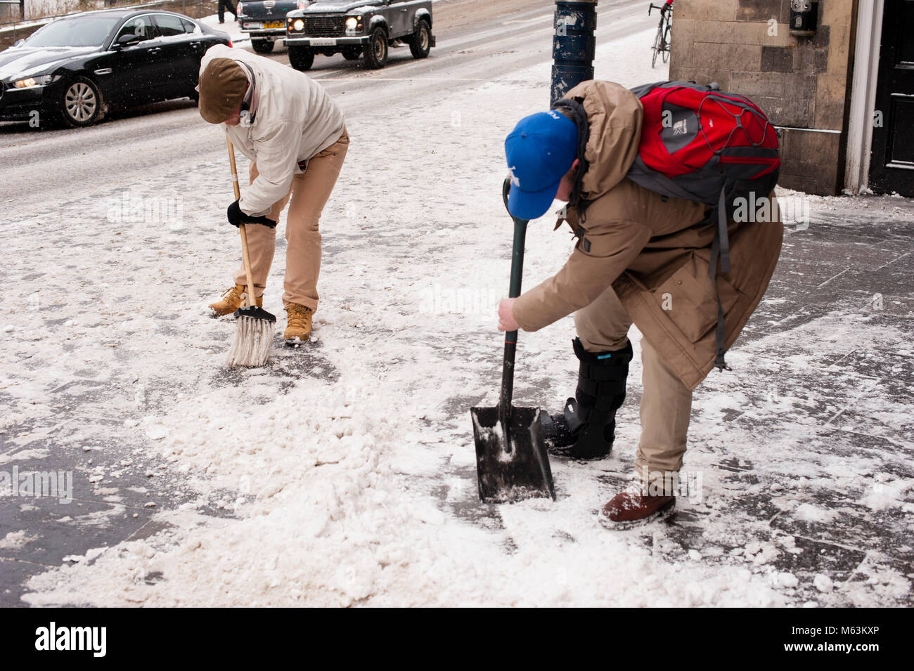 Edimbourg, Ecosse. 28 février 2018.. Météo France : averses de neige en raison de 'bête de l'Est' sur ville d'Edimbourg. Deux mens nettoyage du trottoir. Les attentes pour la journée sont plus averses de neige à cause de la météo fenomenon 'bête de l'Est'. Credit : Pep Masip/Alamy Live News Banque D'Images