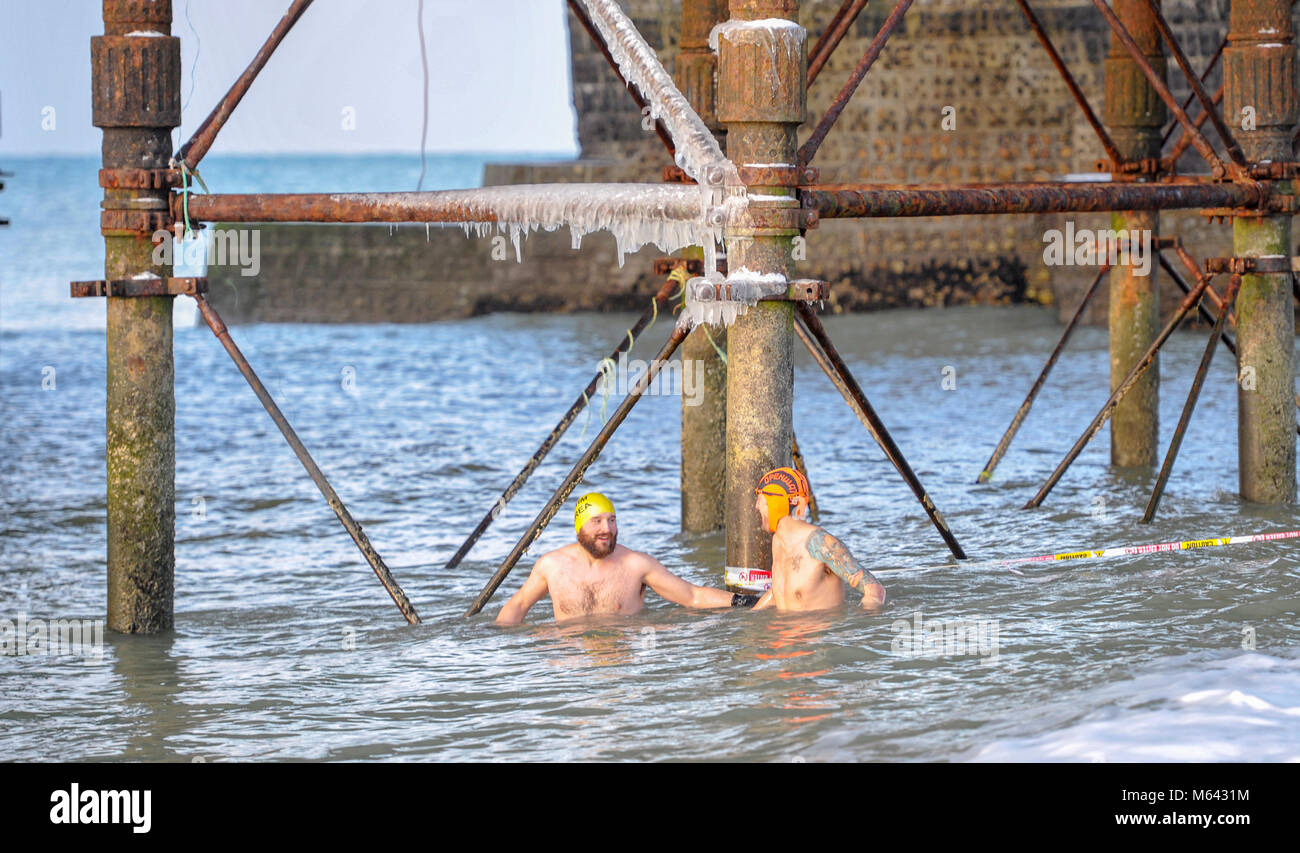 Brighton. 28 Février, 2018. Météo France : avec des glaçons pendant de Brighton Palace Pier Kevin Meredith (à gauche) et un collègue de Brighton Swimming Club profitez de leur plongeon dans la glace ce matin, après une autre chute de neige la nuit . La température de la mer a été mesurée à seulement un peu plus de 4 degrés et dans certaines parties du pays la température de l'air devrait être aussi bas que 11 degrés avec plus de neige et le temps froid prévus pour le reste de la semaine Crédit : Simon Dack/Alamy Live News Banque D'Images