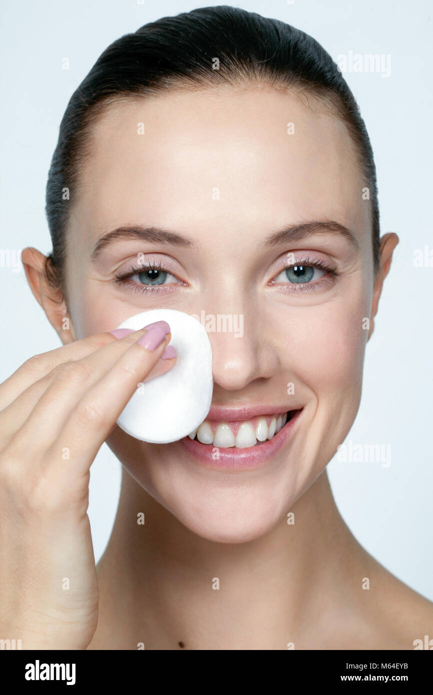 Nettoyage ethnique femme visage avec un coton Banque D'Images