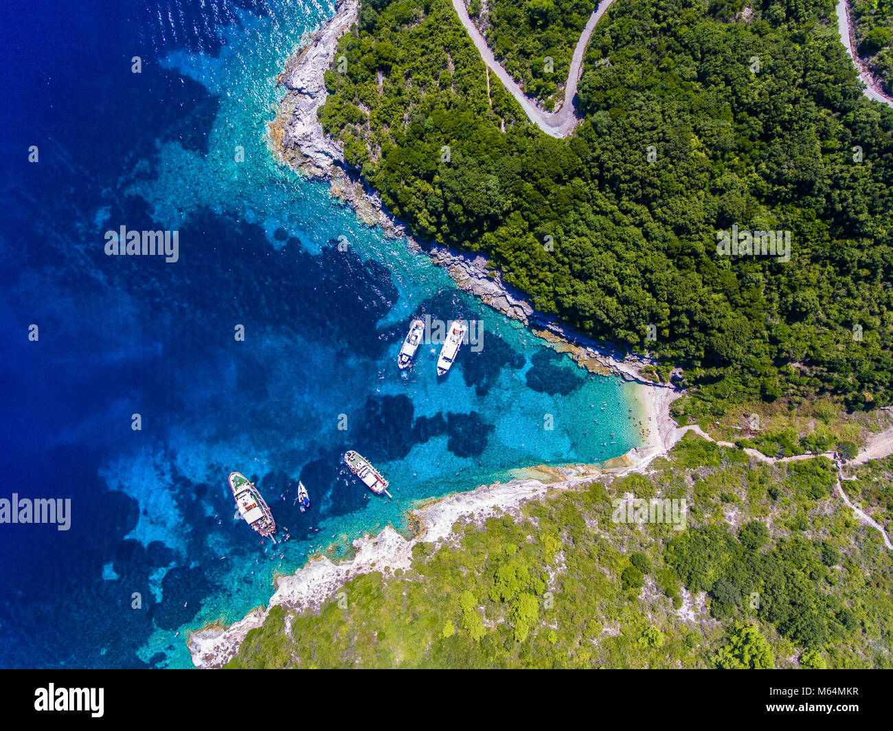 Les gens de nager dans les eaux bleues de l'Île, près de Corfou Antipaxos - Kerkira, Grèce. Vue aérienne d'un voyage en bateau pour la petite île de Gaio Banque D'Images