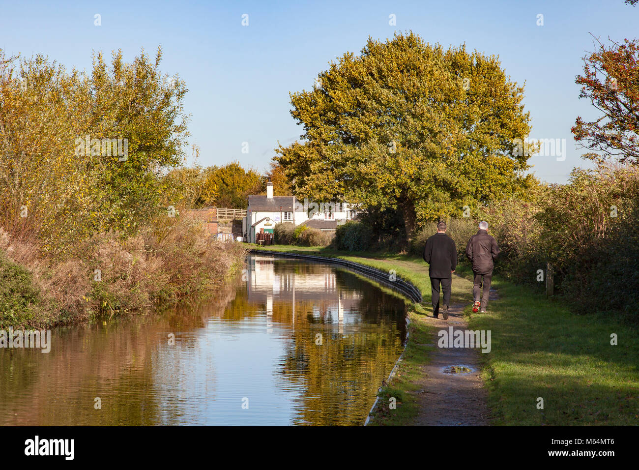 Deux hommes à pied le long du chemin de halage du canal de Trent et Mersey, à Branston, Burton on Trent, Staffordshire, Angleterre de l'Est Banque D'Images