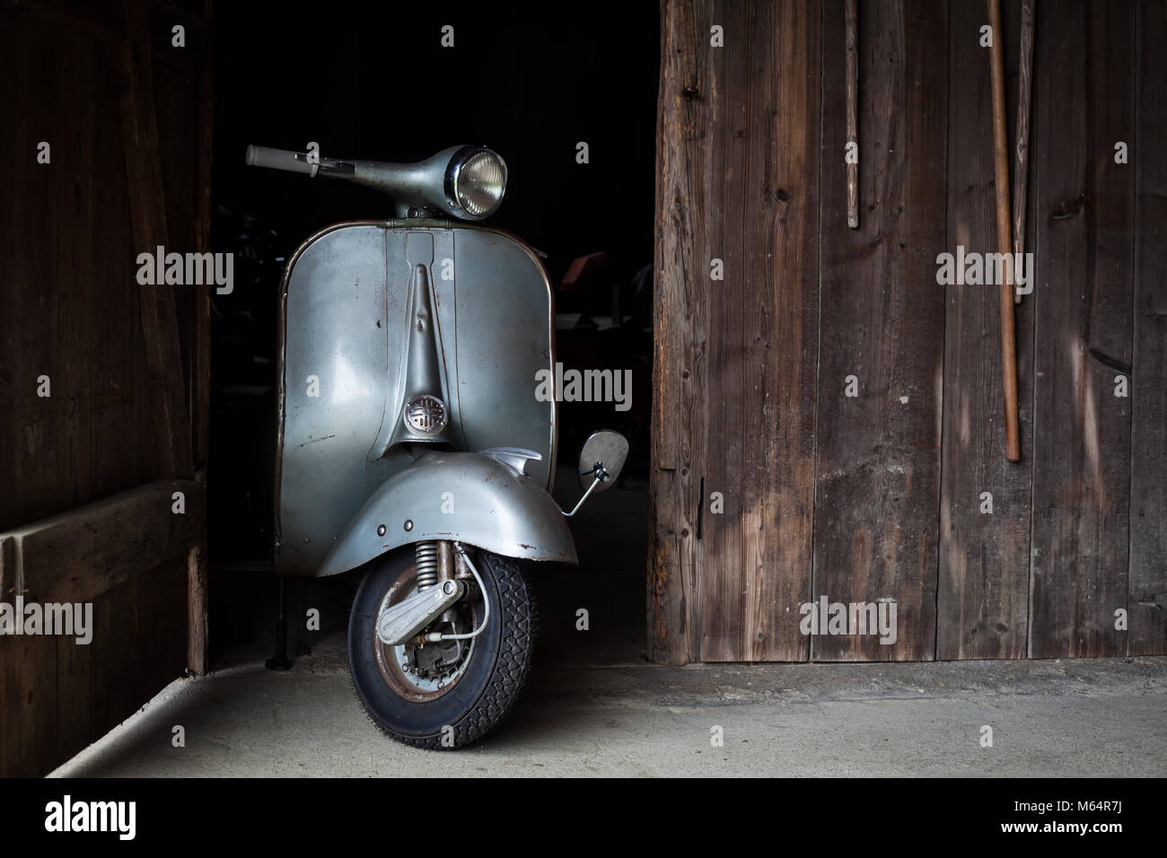 Trouver des vieux grange, Rusty de couleur bleu-gris scooter italien dans une cabane Banque D'Images