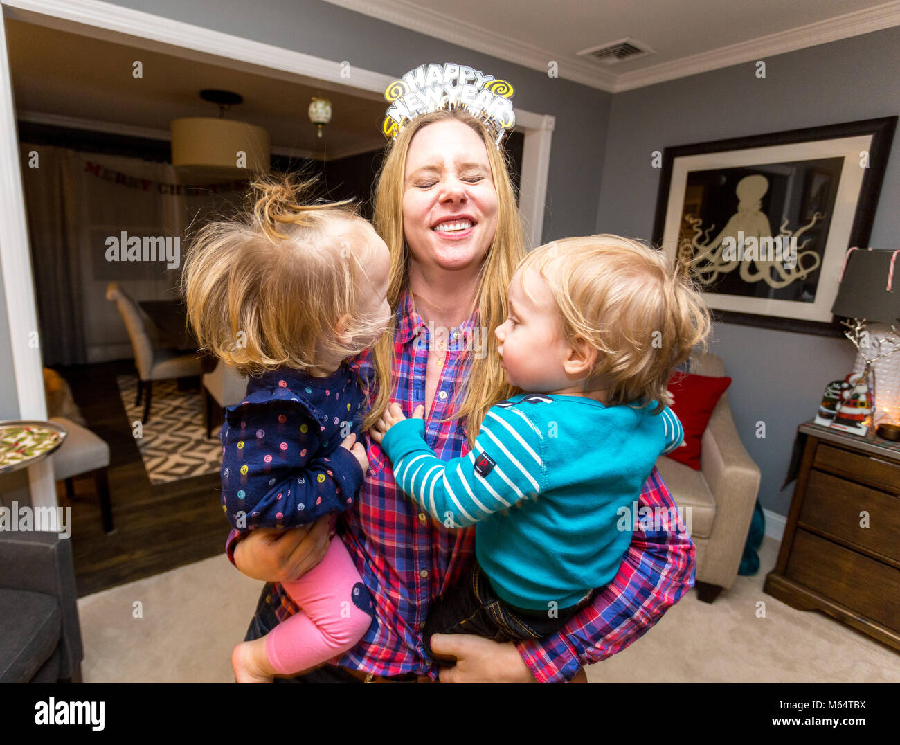 A Young Boy and Girl apprécier le Nouvel An ensemble dans leur maison de banlieue salle de séjour Banque D'Images