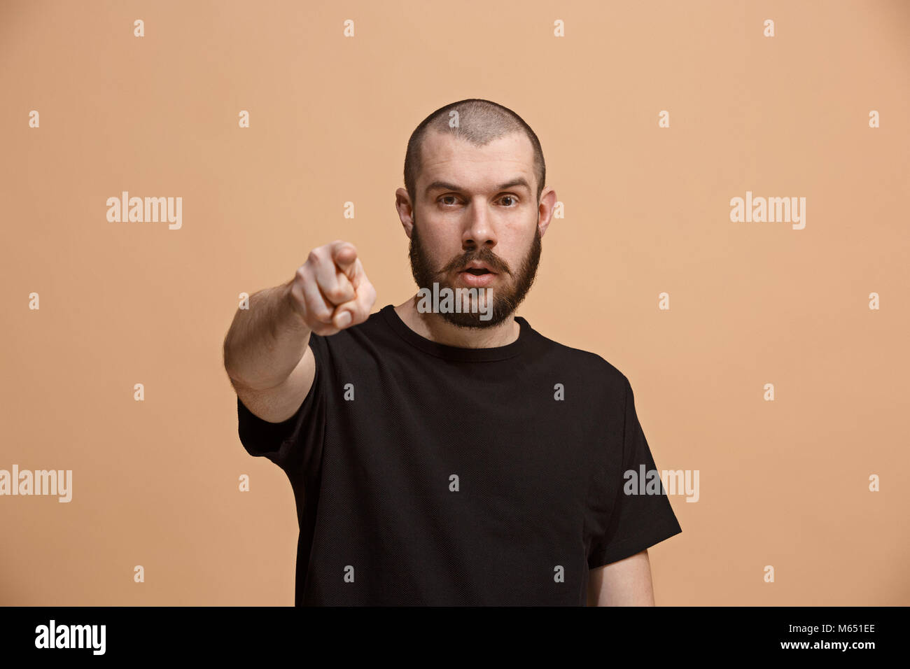 L'homme dominateur et vous voulez vous point, demi-longueur closeup portrait sur fond pastel. Banque D'Images